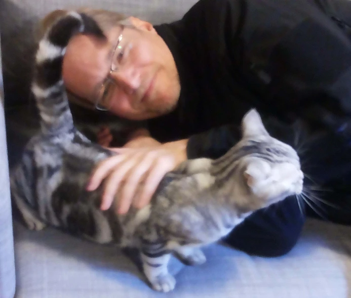 a man and a cat cuddling up to each other