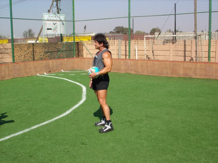 a man is holding a soccer ball and standing on a field