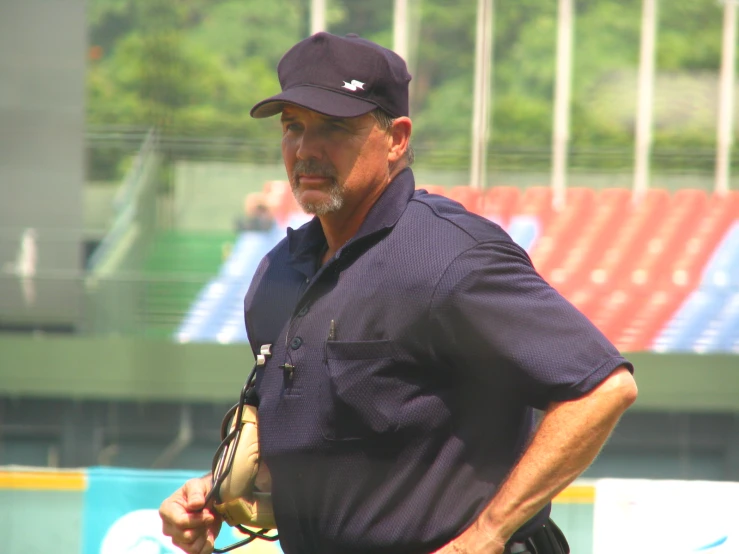 a man standing with a baseball and mitt on his right hand