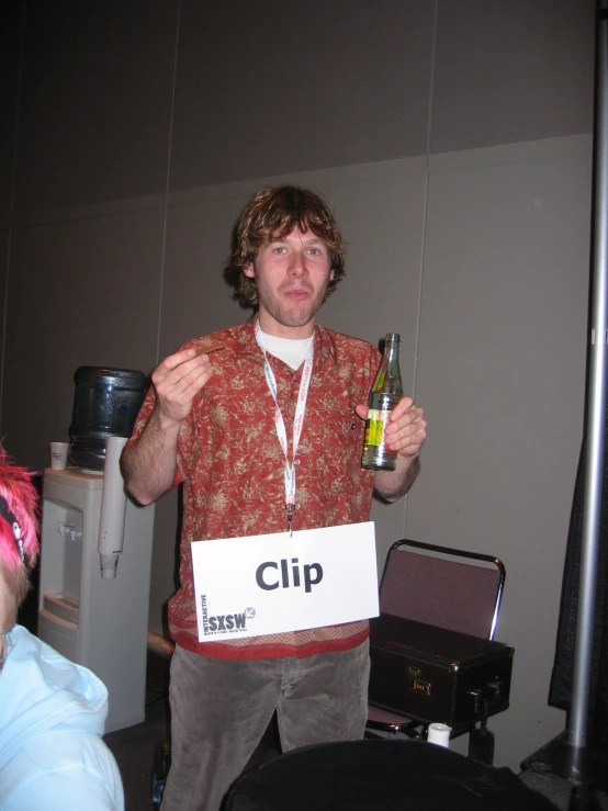 a young man holding a bottle with the name clip on it