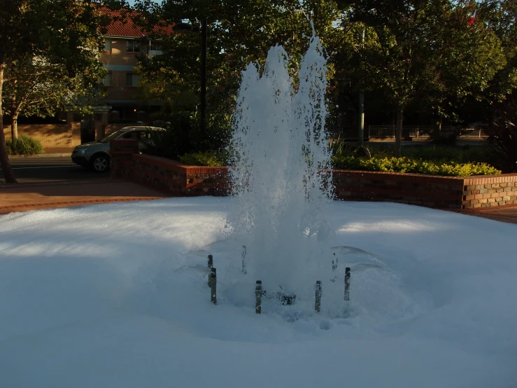 a small fountain is seen here with snow on it