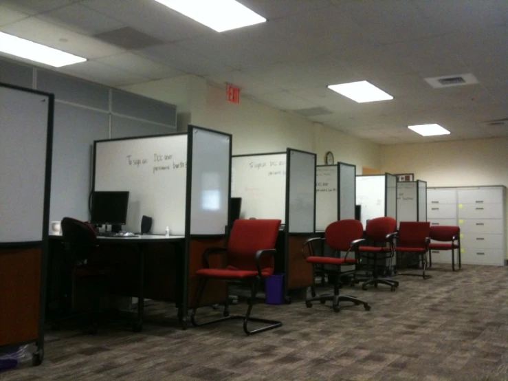 an empty conference room has red and black chairs