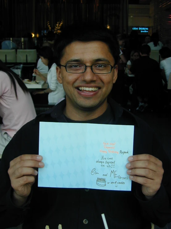 a man holding up a paper with the restaurant's description written on it