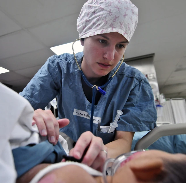 a woman in scrubs looks down at her hand