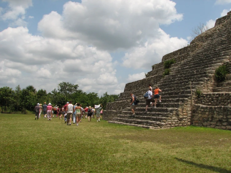 people in a field on the side of a brick structure