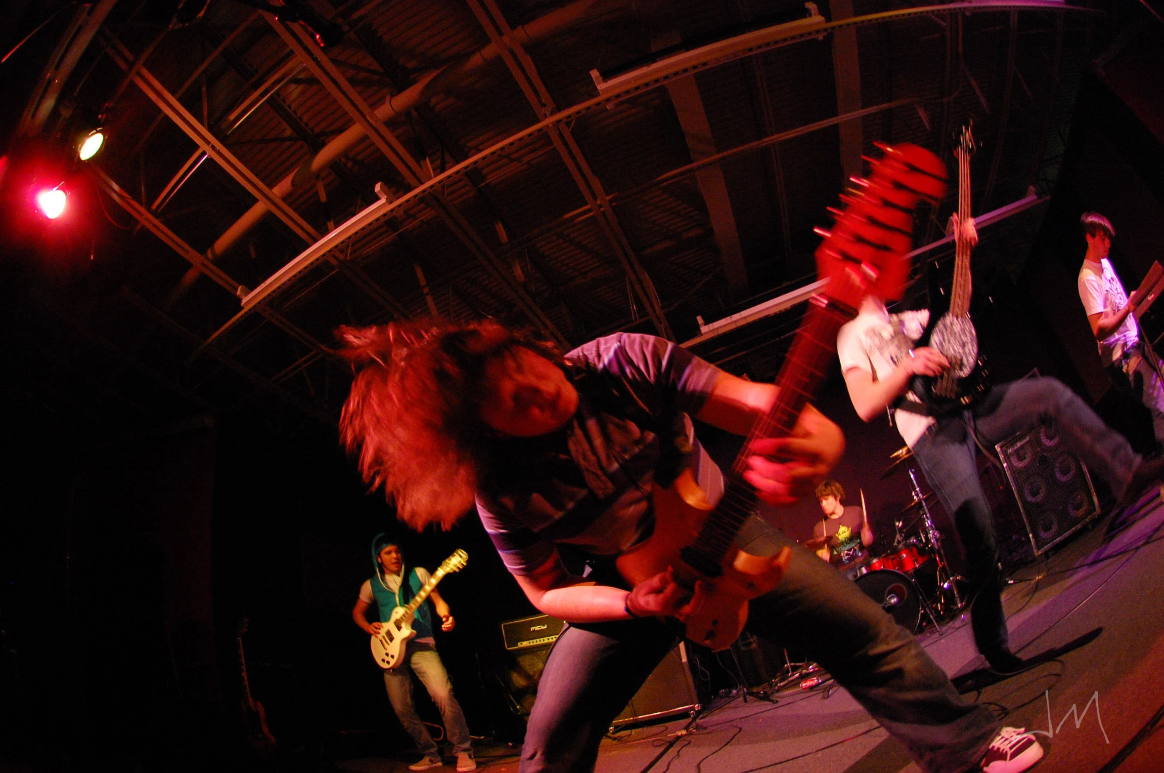 a group of young men playing guitars in a concert