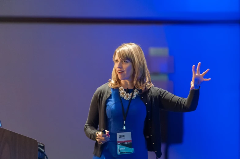 a woman is making a point while speaking at the conference