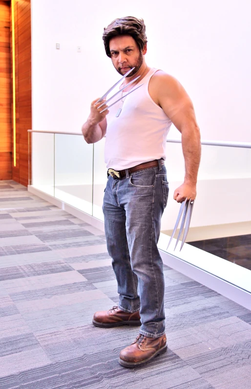 a man in a tank top, jeans and shoes standing on a skateboard