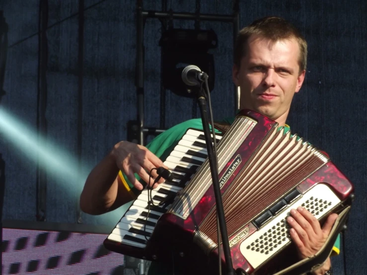 a man in a green shirt playing the accordion