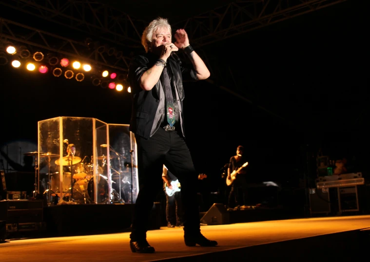 a man performing at an indoor concert in the dark