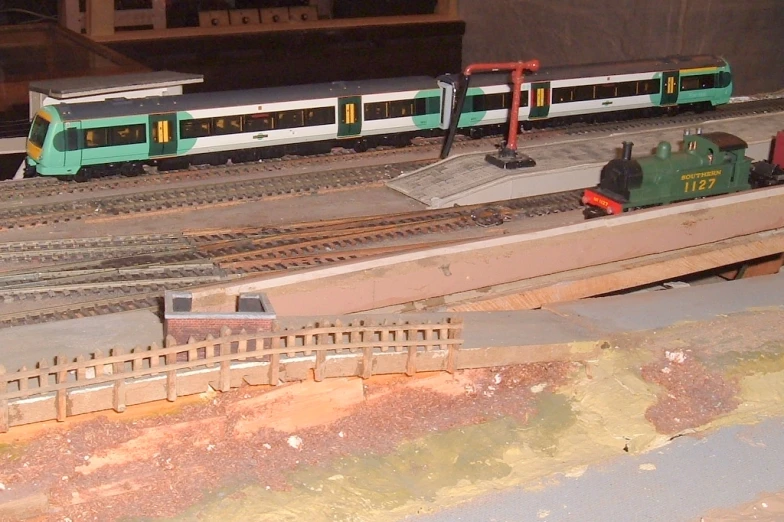 toy trains sitting on railroad tracks on a model track