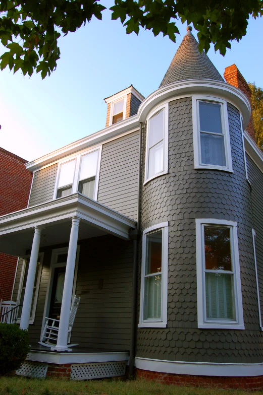 grey home with circular front porch and white windows