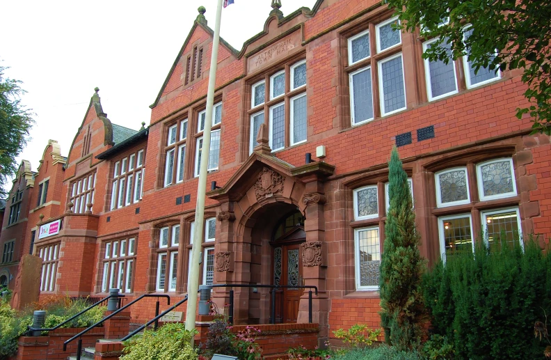 a very tall red brick building with two large windows