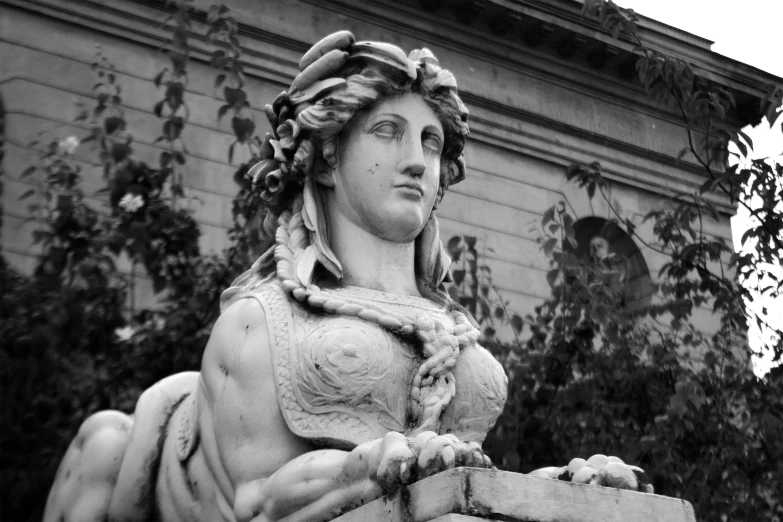 a statue of a woman with curly hair holding a potted plant