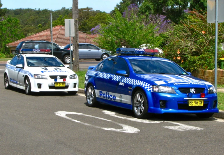 two police cars parked on the side of the street