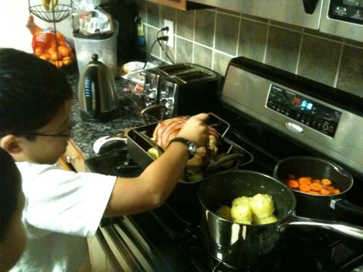 two young children cook in a kitchen together