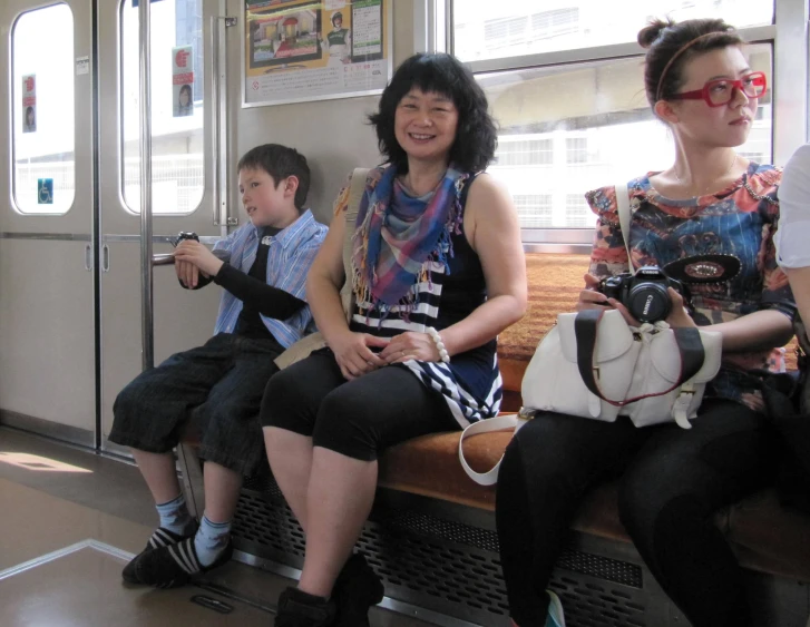 the young people are riding on the train with a few on their laps