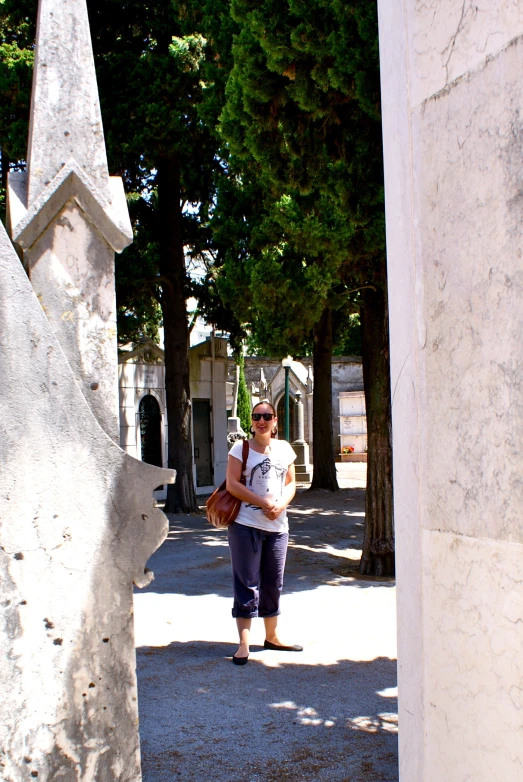 a woman holding a large object in her hands in a cemetery