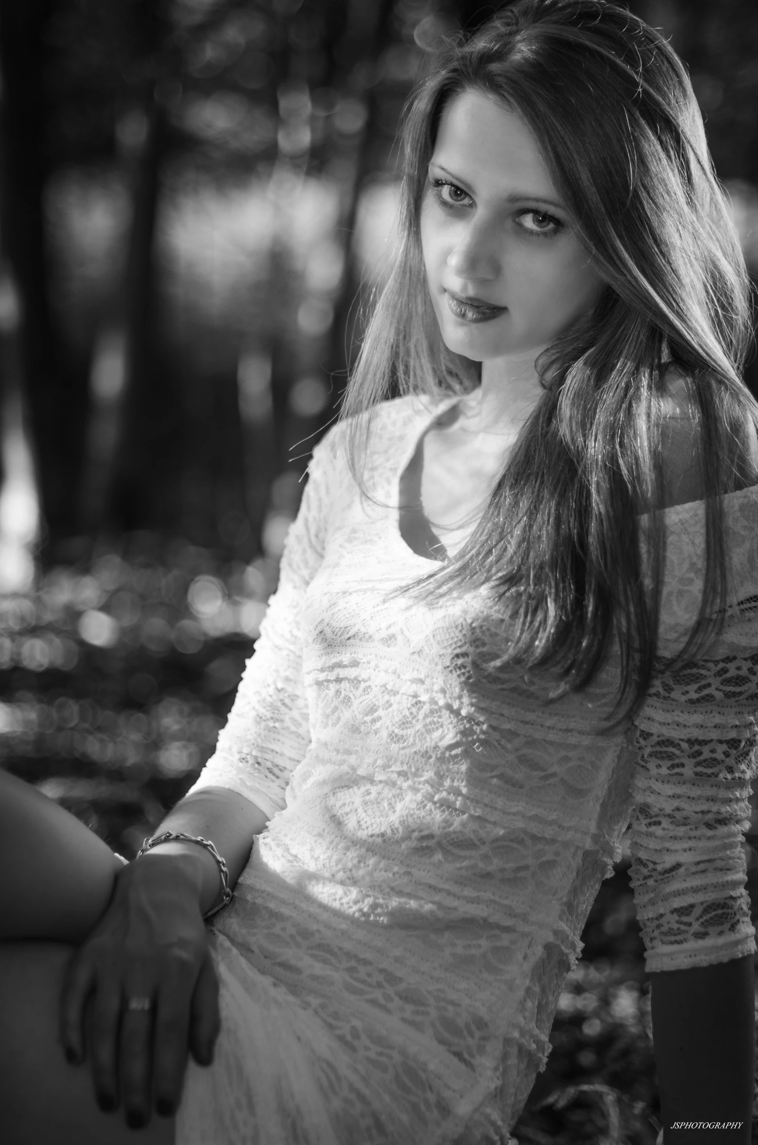 a girl sitting in the woods with a nice dress