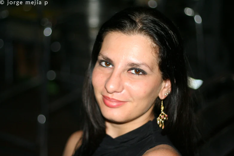 a woman with her hair up, in front of an elevator