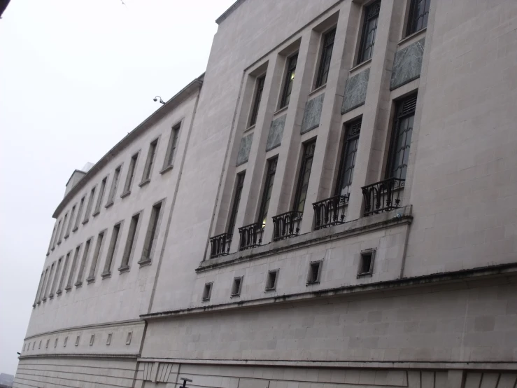 the corner of a building with windows and railings