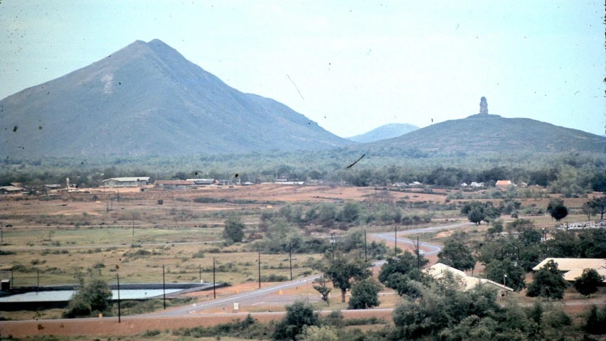 a scenic po of some hills and town near some trees