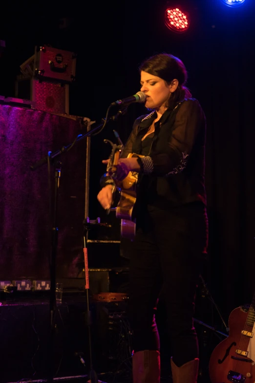 a woman with black hair is playing guitar