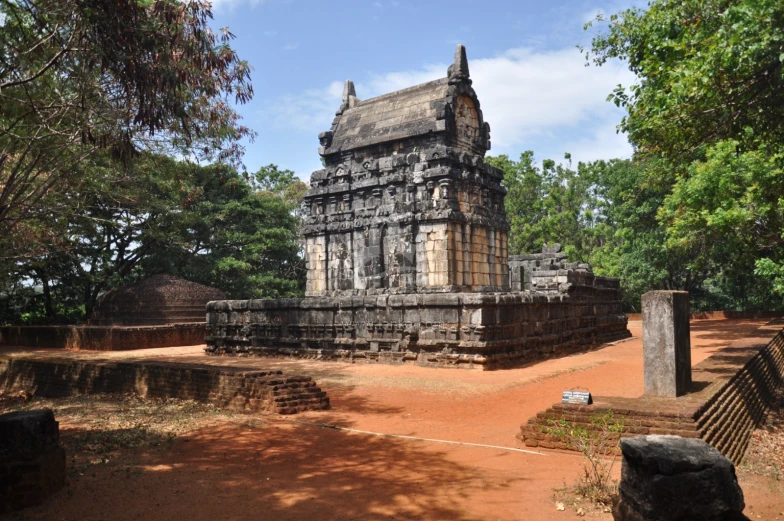 a stone tower with two chimneys is in the middle of a park