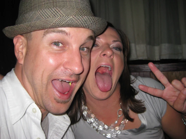 a woman holding her tongue out as a man holds his tongue out