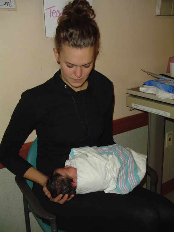 a woman holding a newborn baby in her lap