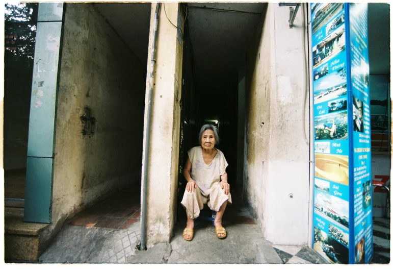 a young person sitting in the corner of a building