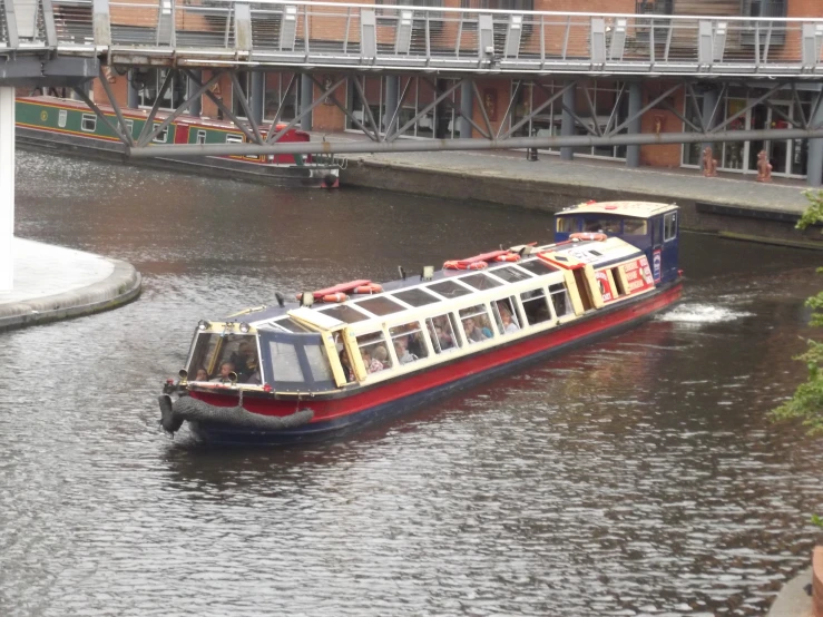 a red, white and blue boat on a waterway