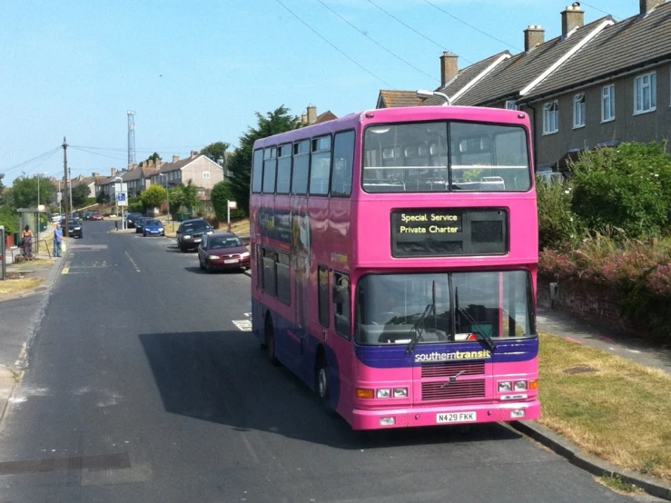 a pink bus parked on the side of a road