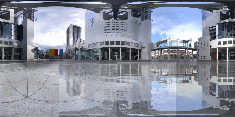 a view through a split po lens of a reflection on the ground in the center of two large buildings