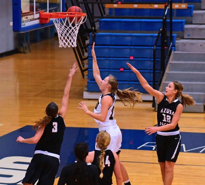 a group of girls are playing basketball on the court