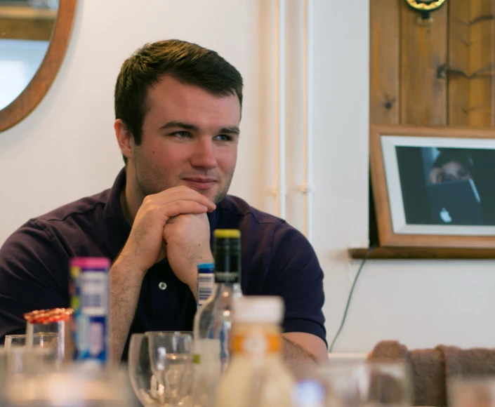 a man is looking ahead while sitting at a table