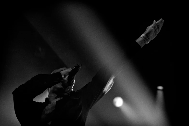 black and white image of a man with his hand up