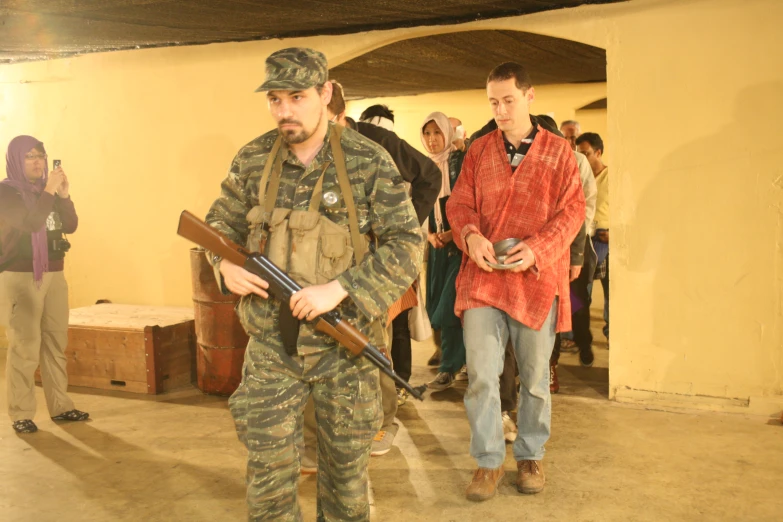 two men in uniform holding guns and talking to a crowd