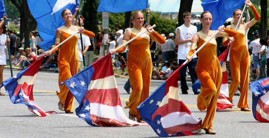 a group of people in orange outfits are holding flags