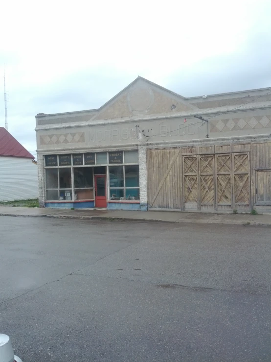 an empty building sitting in front of a street with a fire hydrant in front of it