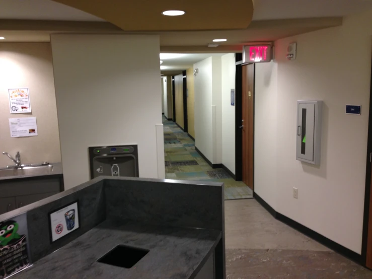 an empty hallway next to a restroom with a washer and dryer