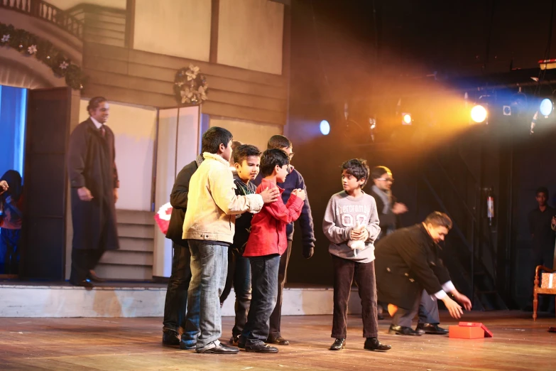 a group of boys are hugging and standing in front of a stage