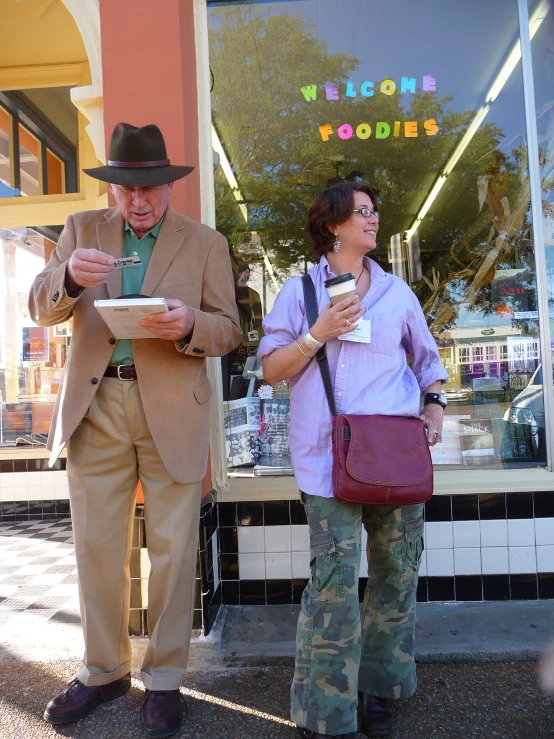 a man and woman standing outside of a business