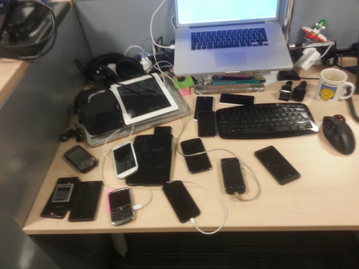 many different electronics are lying on top of the desk