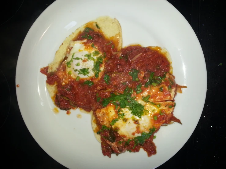 some lasagna with red sauce, with one slice of bread