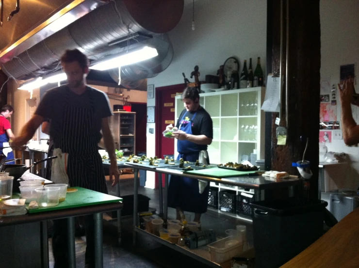 the three cooks in the restaurant are busy with the food