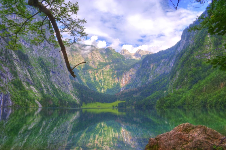 a very large green mountain lake near some mountains