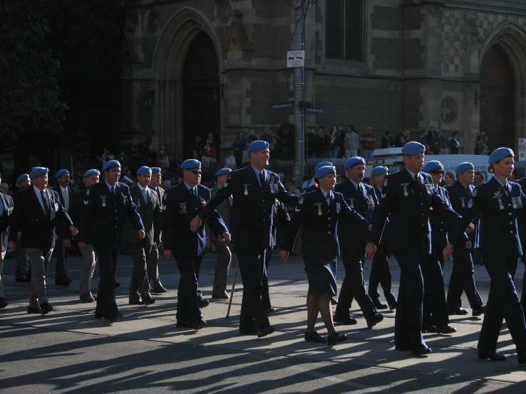 a group of men walking down the road next to each other