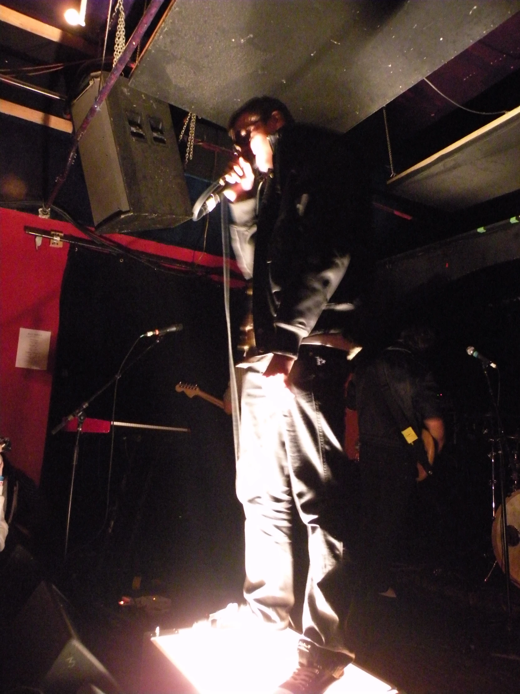 a male standing up with a microphone and lights in front of him