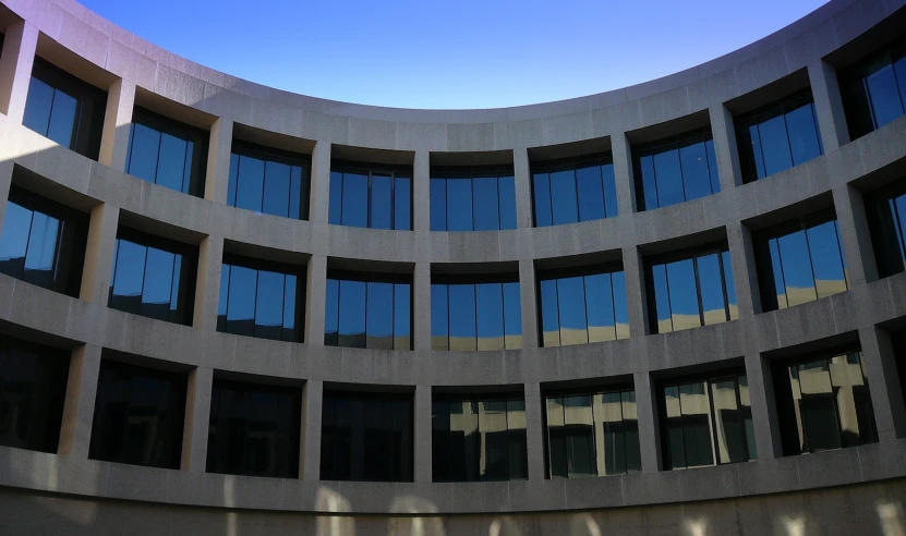 some blue glass windows are in the corner of a building